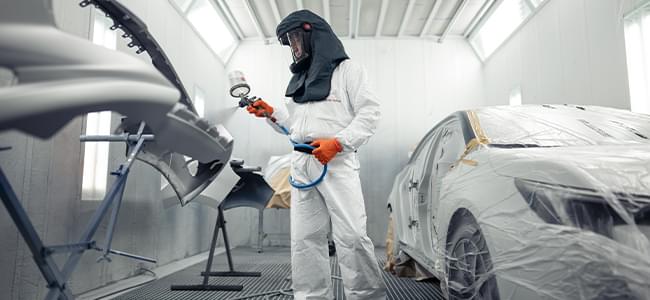 Lakiernik maluje element nadwozia