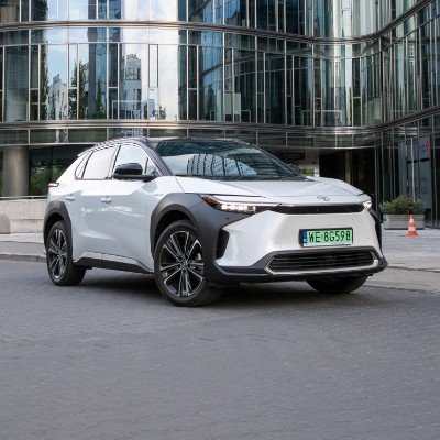 Toyota bZ4X zaparkowana na tle szklanego budynku